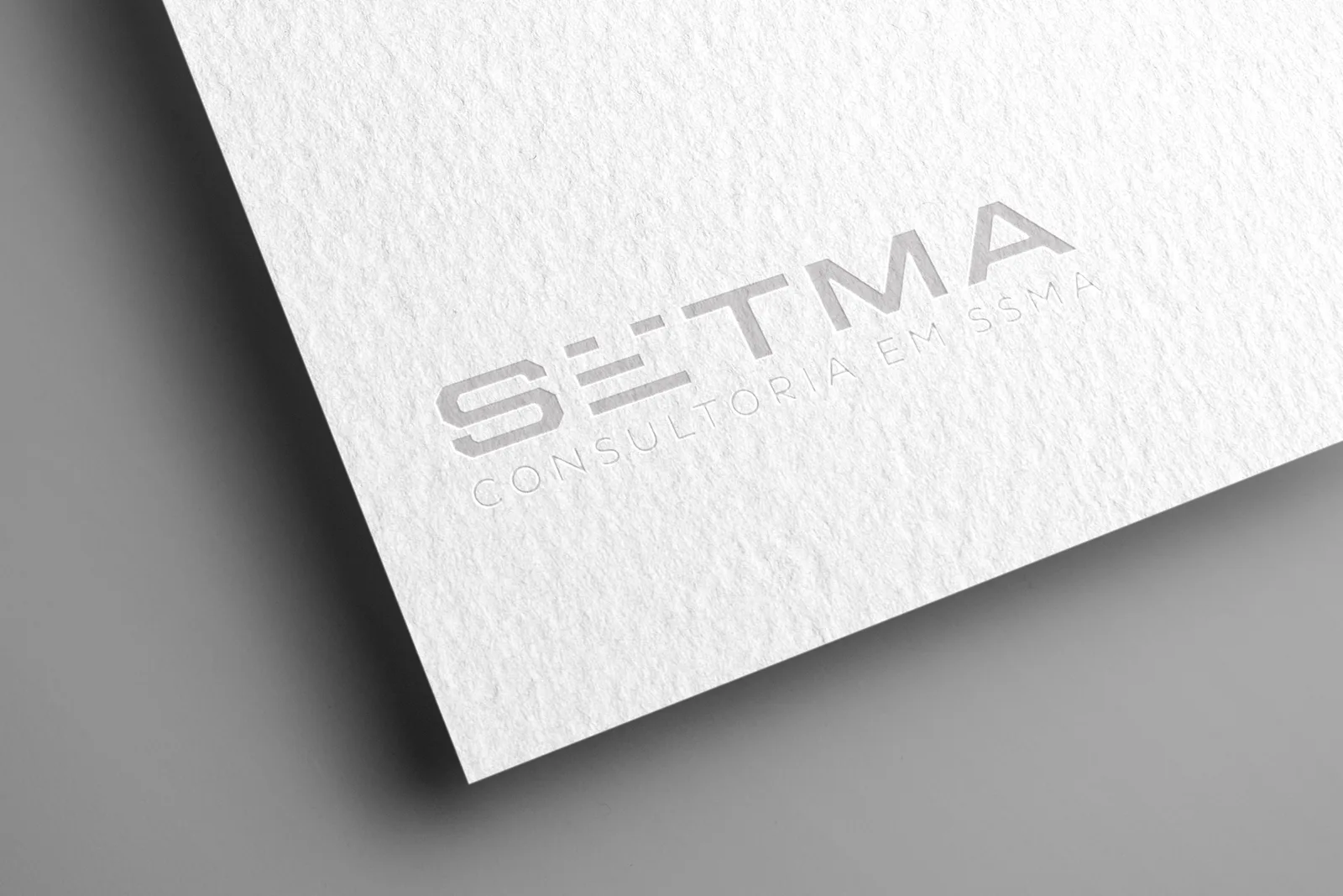 Papel texturizado branco com a marca SETMA em relevo seco