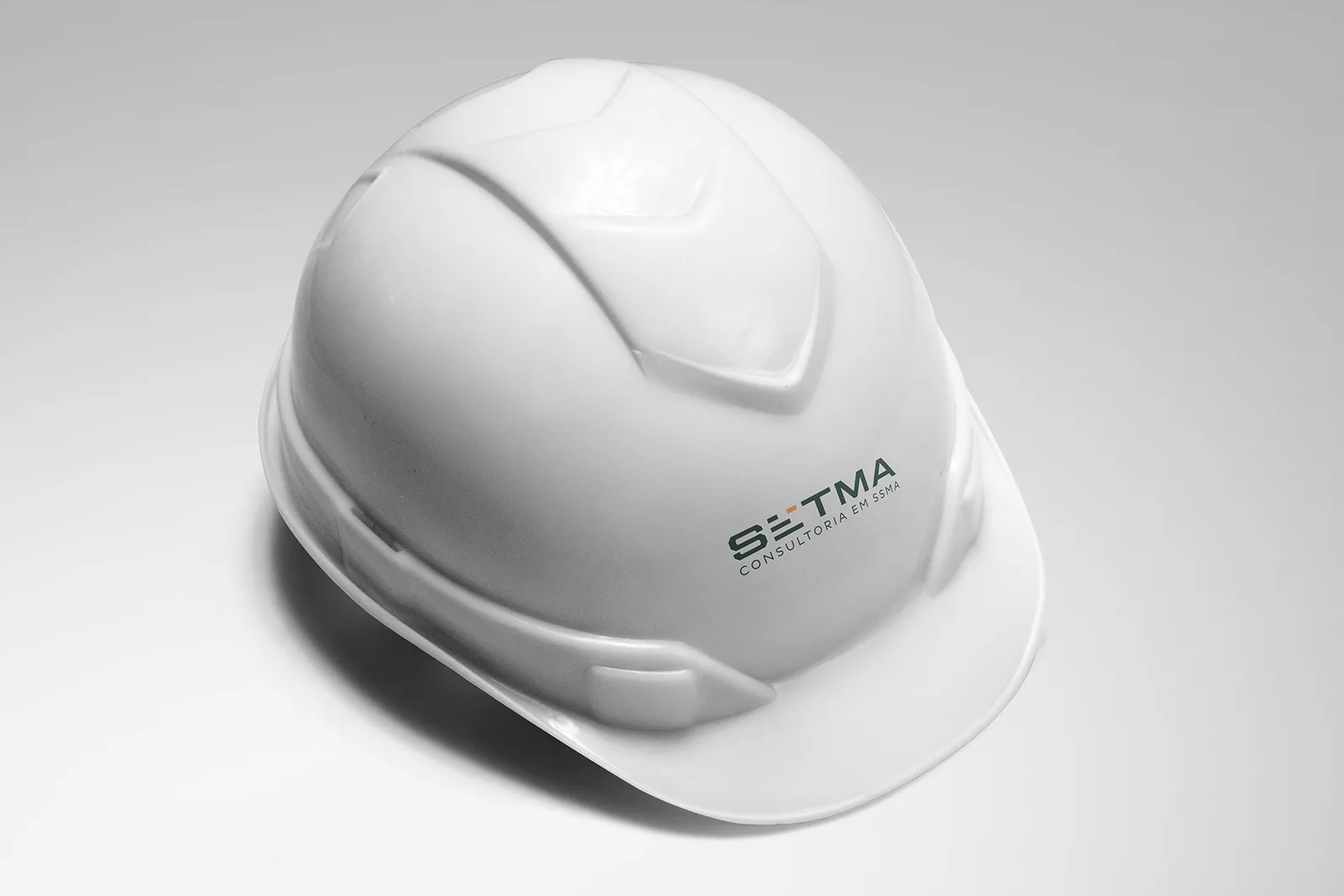 Capacete de segurança branco com a marca SETMA na lateral
